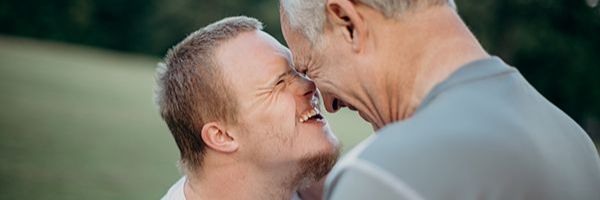 Two people with their foreheads pressed together laughing