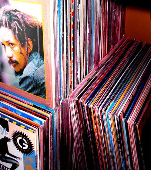 Photo of reggae records stacked together with a face visible on one cover